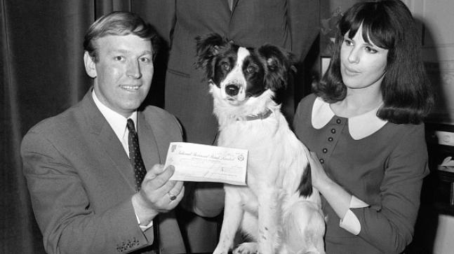 A person and person holding a check and a dog AI-generated content may be incorrect.